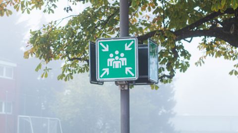 Zeichen für Notfallsammelstellen - Weiße Personengruppe auf grünem Grund